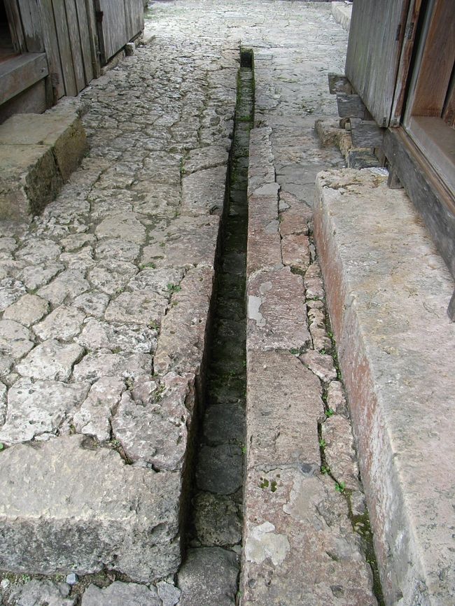 石の使い方は本当に巧みで驚かされます。<br />敷地は庭以外殆どが石畳で塞がれています。ですから雨が降った時の排水にこういった排水溝や、ホンの少し石畳に傾斜をつけたりして排水への工夫がなされています。