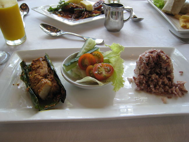 バナナの葉で包んで蒸した魚とレッドライスです。