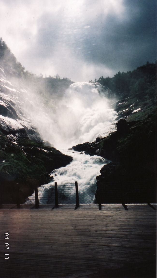 　ミュルダールでフロム鉄道に乗り換え。<br /><br />　駅に着いたときには、既にフロム鉄道が着いていたけど出発時間までまだ間がある。ちょっとのんびりしてフロム鉄道に乗ったら、既に座席はいっぱいだった。やっぱりシーズン中は早く席確保しないといけないのね。<br />　しかたなく、座席がない車両でずっと立って景色を見てた。<br /><br />　写真は途中のヒョース滝。名所らしくて、ここで数分停車。反対座席の人も一時下車して写真撮れるようになってた。