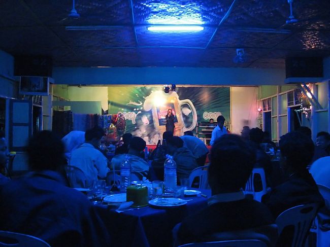 宿が決まれば、次は生ビール。<br /><br />シットウェーでは電波塔から大学通りへの右側の店(店名不明)と、海岸通りのCiry Pointと市場の間にある「May Yu」(写真)で、生ビールが飲める。<br /><br />「May Yu」には、カラオケレストラン(生ビール550K、料理は上質)、マッサージ(45分3000K)、ゲストハウス(外国人不可)がある。まぁそういう所なので、繁盛しているみたい。<br /><br />7時ごろから歌が始まり、それからは爆音。話が出来ないほどなので、屋外の席を取ったほうがいいかも。<br /><br />いつも感じるんだけど、こういうところの「歌のお姉さん」が上手いと思ったことがない。PAの酷さもあるけど。<br /><br />ミャンマーの人々はほんとうに歌が好きで、、アイロンかけながら、バスに乗りながら、マッサージしながら、自然に歌ってくれる歌はほんとうに素敵なのに。