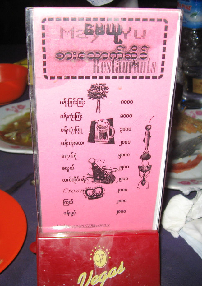 さて、店内に入るとほぼ満席。<br />どうしようかなぁとおもっていると手招き。<br />某所で僕のパスポートをチェックした役人さんでした。<br />良い出会いをした人で、嬉しい再会でした。<br />駆けつけ生ビール。<br /><br />こういう場合は、こちらのおごりも、<br />割り勘も効かないことが多く、<br />相手のおごりになってしまう。<br /><br />『税より袖の下』の腐敗がまかり通るなか、<br />『袖振る余裕』からおごってもらうビールは、<br />あまり美味しくない。<br />それを疑う自分は恥ずかしいし、<br />とても楽しいひとときだったんだけど。<br /><br />代わりに「歌のお姉さん」にレイやら王冠やら(写真)をあげようかと思ったけど、高すぎ。