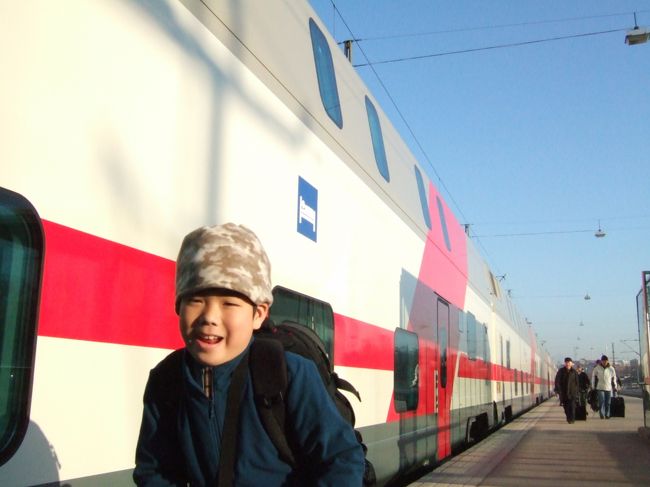  昨日の夜は、ぎりぎりまで窓に顔をつけて夜空をみていました。オーロラをみたという人の話を聞いていたので。。オーロラは見えませんでしたが夜のフィンランドのしーんとした空気と自然を堪能。<br /><br />　寝ている間にヘルシンキの町のど真ん中に到着するというのはとっても快適。朝の景色を窓からながめながら、Ｓ君は朝ごはんに昨日のピザの残りをぱくついていました。駅には静かに到着。<br /><br />　ながーいながーいプラットホームを歩きます。<br />　自分たちの泊まった部屋の下あたりでハイ・チーズ。<br />　