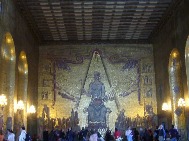 ゴールデンホール。壁一面に１８００万のモザイク画がありきらきら輝いています。ここも７００席のバンケットホールになります。正面の女性はスウェーデンの女神メーラレン湖の女王様が、世界中から称えられる様子が描かれています。