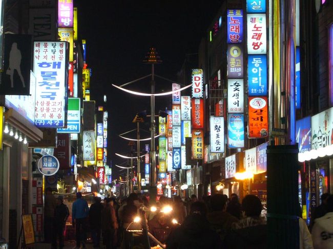疲れたので、適当に市バスに乗ったら、電車で２駅ぶん先まで行ってしまった（笑）。なんとか、スウォン駅に戻って来たら、すっかり陽は西に。<br />夜の繁華街も、雰囲気は、日本とまったく一緒。<br />