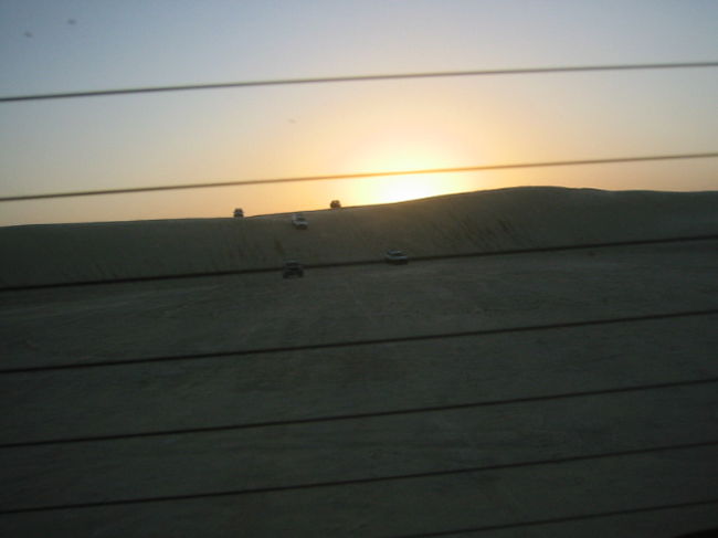 ４ＷＤ後方ガラス越に砂丘をぶっ飛ばす４ＷＤ郡を