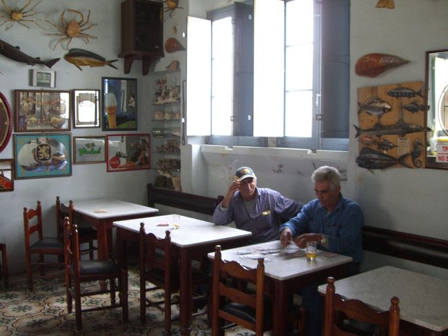 グレーンイーグルスでカードに黙々と興じる地元客。一見とっつき難い頑固そうなオヤジたち。<br /><br />”その社会には階層がないという点で、彼の経験に照らすとユニークな島だった。もっとも貧しい漁師でさえ、もっとも豊かな地主となんら変わらないと思っている。自分が他人より優っていると思うものはゴソへ近づかないほうがいい。騒々しくて陽気で、ひとたび知り合いになれば親しくなる、そういう島民気質がクリーシィの記憶に残っていた。”（”　”は集英社文庫「燃える男」より）<br />