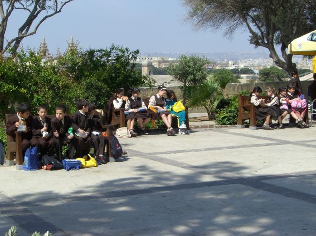 アッパー・バラッカ・ガーデンで見かけた遠足の小学生たち。狭いベンチに仲良く座って楽しそう。陰湿なイジメなどとは無縁の雰囲気。思い込みかしらん？マルタでは学校の費用はタダ、医療費もタダのだとかで、大層住みいいのだとガイドさんは言っておりました。<br />