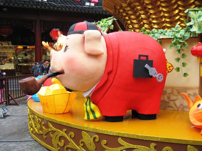 下の台にも豚さんがいました。中国帽を被り、パイプを咥え、赤い背広に黄色いタイ姿です。お腹の鞄は、サラリートンのシンボルでしょうか。