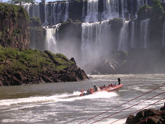 アルゼンチン側の船。<br />滝のすぐ側から出発。<br />防水袋を渡され、救命胴衣を着用。<br />滝の下まで来ると、<br />「go!go！」の掛け声とともに、<br />船首を滝に突っ込ませる。<br />船上から歓声があがり、アンコール。<br />再び滝へと向かい、<br />ゆっくりと、更に奥まで突っ込んでいく。<br />滝の水は冷たく、気持ちが良い。<br />目を開けていようとの努力も虚しく、<br />水圧で目が勝手に閉じてしまう。<br />閉眼直前の視界は激しく流れる水の色。<br />すなわち真っ白。<br />アルゼンチンの船は、ブラジルの国境なんて、<br />何とも思っていない様子。<br />ブラジル船は<br />国境を越えないように気にしているのに（笑）<br /><br />
