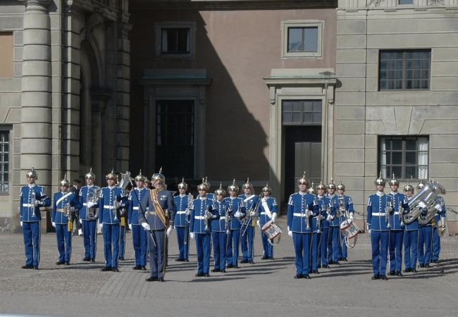 王宮内の衛兵の交代式。毎日12時に行われる。<br />12時近くになると、門の中へ大勢の観光客が集まる。停止線から中に入れないが、至って物分りの良い守衛で野暮な事は言わない。外から軍楽隊勇ましい楽音が聞こえてくるが、軍楽隊は中々姿を現さない。心憎い演出だ。じれていると軍楽隊とともに、突然、20人余りの衛兵が姿を現す。衛兵自体は他国のように選抜された兵でなく、徴兵された若者である由。この国は徴兵制度がある数少ない国の一つだ。
