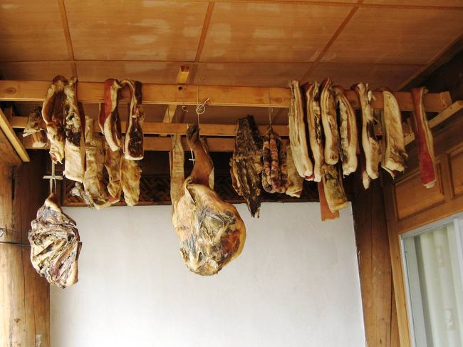 2階の廊下に吊り下げてあった肉です。ハムにするための豚肉のようです。門の右手の囲いでは、白い豚が飼われていました。