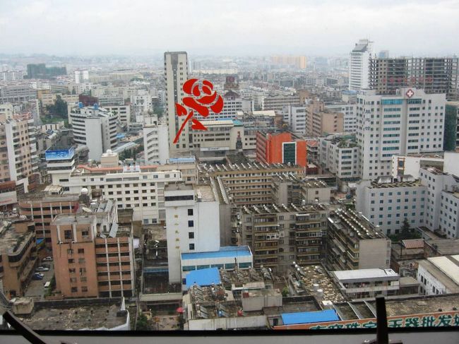 食事の後に、展望レストランをぐるりと回って、昆明市内の写真を撮りました。その一枚です。ガラスに描かれた赤薔薇が一緒に写りました。