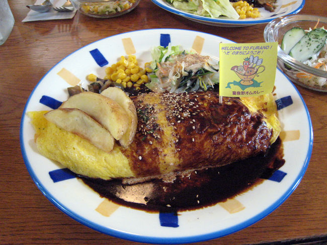 富良野のオムカレーには、6か条があるらしい。<br /><br />第1条　お米は富良野産を使い、ライスには工夫を。<br />第2条　卵は原則、富良野産を使い、オムカレーの中央に旗を立てる。<br />第3条　富良野産チーズ(バター)、又はワインを使う。<br />第4条　野菜、肉、ピクルスなども富良野産にこだわる<br />第5条　富良野産食材にこだわった1品メニューと『ふらの牛乳』をつける。<br />第6条　料金は税込み1000円以内で提供する。<br /><br />とにかく、富良野産の食材を使用した、一品ってことですね。しかし『ふらの牛乳』が切れていたため、飲めなかった。なんか、悔しい。。。<br />味は、全体で言うと、そこそこ美味しかったかな。<br />