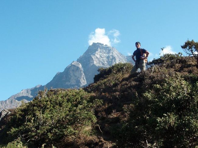 クンビラをバックにガイドをしているシェルパ。