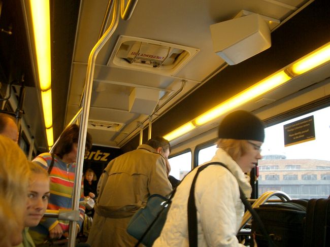 10/22 昨晩のタイガースVSカージナルスの<br />試合の余韻が残るデトロイトを出発です。<br /><br />空港ターミナルに向かうバスの中です。<br />写真の白いコートの品の良さそうな女性と、<br />ちょっとした出来事が・・。<br /><br />女性「あなたはタイガースファン？」<br />Mai 「ええ」<br />女性「私は、カーズ（カージナルズファン）」<br />と言って、この女性は、白いコートを脱ぎ、<br />真っ赤なTシャツ姿に・・・・。<br />そして「ゴー、カーズ！」と叫ぶのです。<br /><br />Maiは、びっくり仰天。<br />「私は、日本からデトロイトに来てるの、<br />　両チームが良い試合をして欲しよね・・」<br />と説明を・・。<br />こんな時は英語が流暢に出てくるから不思議です。<br />火事場の何とか力でしょうか？