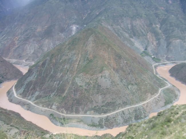 途中で、金沙江の流れがオーム型に湾曲する場所で<br />写真を撮りました。<br />写真のそのまんまの光景がそこにありました。<br /><br />川向こうは四川省で、四川省と雲南省の携帯電波が交差するエリアらしく、ショートメッセージで、<br />四川省と雲南省の中国移動から<br />メッセージが送信されてきました。