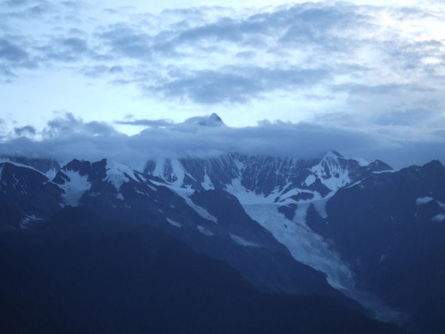 夕暮れの梅里雪山。<br /><br />雲がかかってて、ようやく主峰の頭がちょっとだけ<br />見えました。<br />翌日は早起きしてサンライズを見ます。<br /><br />ここで驚いたのが、こんな僻地にも外国人向けの<br />ちょっとしたカフェバーがあって、<br />インターネット（ブロードバンド）が<br />できたことでした。
