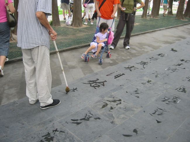 おじさんが水で文字を書いていました。<br />達筆です。