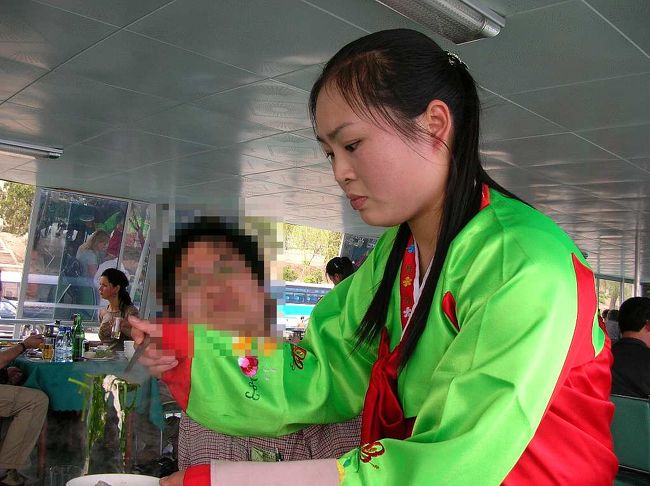 案内同志の撮影。<br /><br />　鍋の内容物が、チュチェの教えのごとく、平等に盛りつけられるよう真剣な眼差しで作業する服務員と間抜けな倭奴（おいら）。