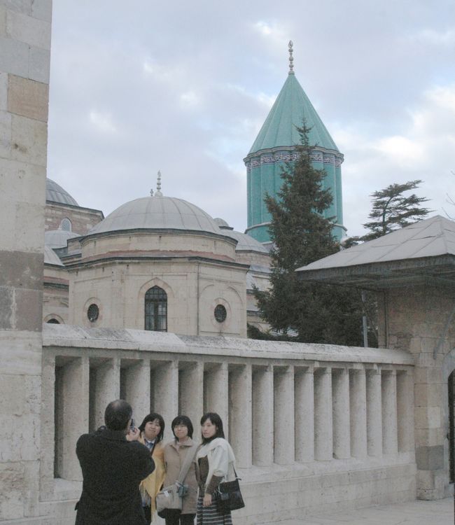 後ろの青い塔が、メヴラーナの廟。<br />メヴラーナ教団は激しい踊り「旋舞」で有名である。年1回、伝統を受け継ぐ実演が行われる。<br />4時半、博物館を出発して、カッパドキアへ出発する。<br />220km、3時間の道程である。<br />途中のアクサライの隊商宿（キャラバンサライ）前の土産物屋にて休憩する。ここの隊商宿は補修復元されていて完全な姿で見ることが出来る。しかし真っ暗なため写真を撮ることは出来なかった。この辺は国道に沿って、15−20kmの間隔でシルクロードの隊商宿が、今でも残っている。