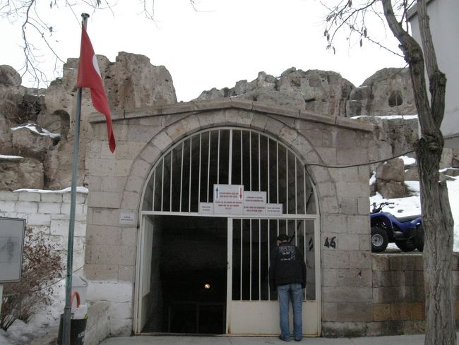 カイマクルの地下都市入口。<br />地下都市の通路は狭いので、入ると、4階建てのビルを上下することになりますが、1人だけ引き返すことは出来ませんよと念を押されてしまう。<br />この地下都市の発見は比較的新しく60年前であるとNHKの探検ロマン世界遺産で紹介していた。最初の住民はビザンティンの偶像破壊運動を逃れたキリスト教徒で、オスマン・トルコの攻撃を避けるために多くのキリスト教徒が逃げ込み、3000人が生活していた。蜂の巣上に洞窟内部を拡げ、地下水脈に通じている垂直の換気口があり、新鮮な空気が供給された。住居、炊事場、穀物貯蔵庫、ワイン製造所、家畜小屋、教会、墓間であった。通路は迷路になっていて、道をふさぐ可動式の大きな石、狭まった通路の横壁に開けた穴から槍を射して敵を仕留める工夫もしてあった。