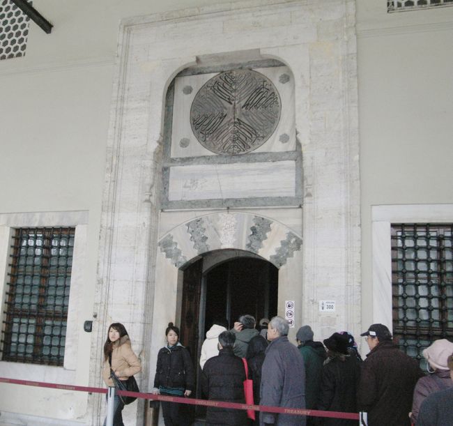 宮殿内では自由行動となる。<br />お目当ての宝物館内は撮影禁止である。お目当ての世界最大の86カラットのダイアモンドやエメラルドをちりばめて短剣は壁面のケース内に収まっている。前に来た時には陳列台にあったように思うが、観光客増加で致し方ないのだろう。<br />「聖遺物の間」が1番混んでいた。ここはムハンマドの足型、髭、着用したマントが陳列されている所だ。館内は聖職者のコーランを朗読する声が鳴り響き、荘厳な雰囲気に満ちていた。この季節、欧米の観光客よりトルコ国内の観光客が多いのだろう。<br />写真は聖遺物の間の入口。