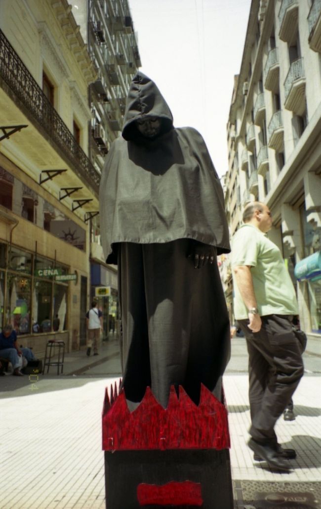 不気味な芸人。コンタクトなのか、目が真っ白。<br /><br />コインで何やら懐からゴソゴゾと取り出すと、パッと光ります。そして、その手から何やらラッキーアイテムと｢幸あれ！」みたいな文言が書いてある紙をくれました。