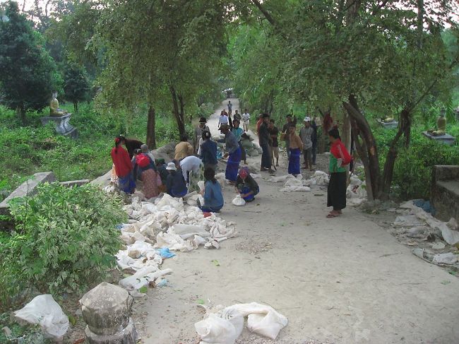 トラックでやってきた青年男女が、それぞれに砂袋を担いで登ってゆく。