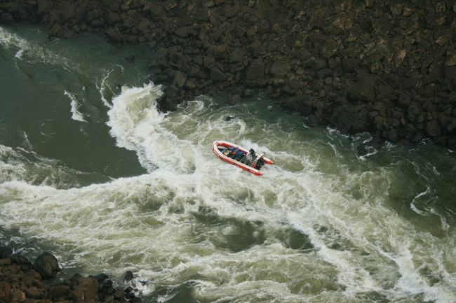 小さなゴムボートに乗り、滝の中に突入するツアーに参加している人たち。