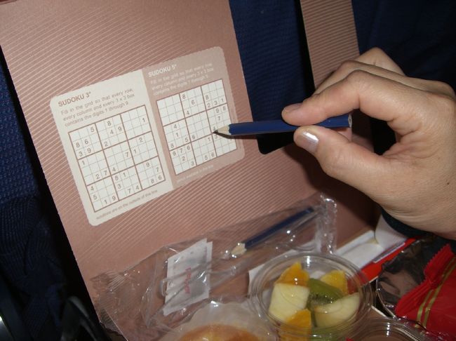 ☆ＫＬＭ（エコノミー）の食事<br /><br />ナイフ・フォークと共に鉛筆も添えられていて「これは何じゃいな？」と思っていたところが、ボックスのフタに数字パズル（数独：sudoku）が印刷されていたりする。実際にパズルに興ずる人が居るかどうかはともかくも、そのご愛嬌は私たちの気に入るところ。ちなみに、ウチの家内はしばらくパズルと格闘しておりました。<br /><br />ＫＬＭの評判は色々のようですが、＜エコノミー席としては＞全体的に好印象を私は持ちました。一言で言うと「気持ちの良い合理性」。座席も比較的ゆったり出来ました。サービスもキビキビとしたものでした。思い込みかもしれませんが、日本人とオランダ人とは感度が近い部分があるようにも感じました。<br /><br />食事もランチボックスのスタイルで、料理やナイフ・フォーク類の納まりがとても宜しい。トレーの上がお祭り状態にもならないし、食中・食後ともに快適。量も適当。味もエコノミーとしては上の部類かと思いました。<br />