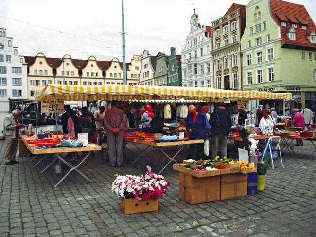 マルクト広場で\100ショップならぬ１マルク（９９ペニッヒ）ショップをはじめて見る。<br />背後に広場を囲む切妻の家が見える。