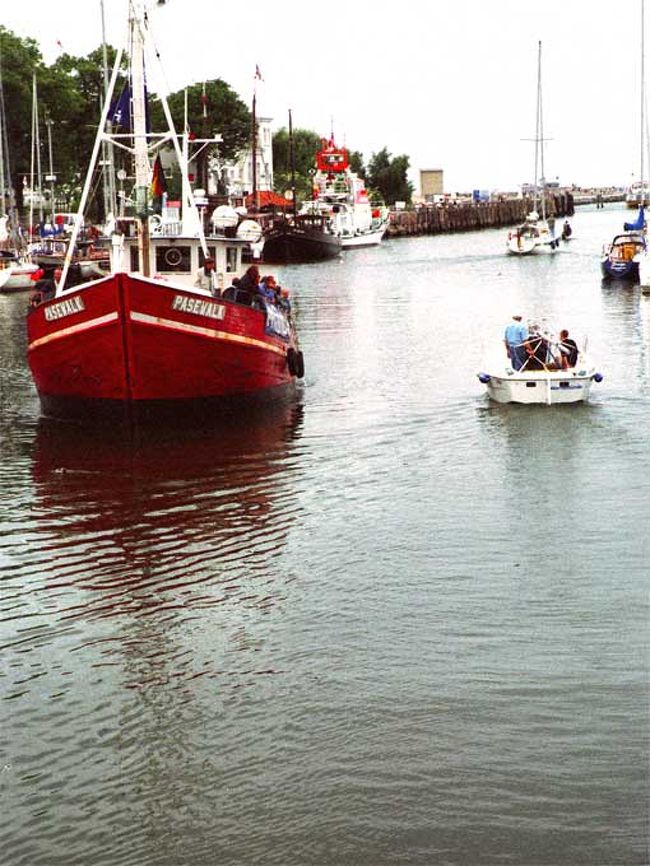 河の風景。手前は帰港する漁船と小型ボート。奥に出港する帆船
