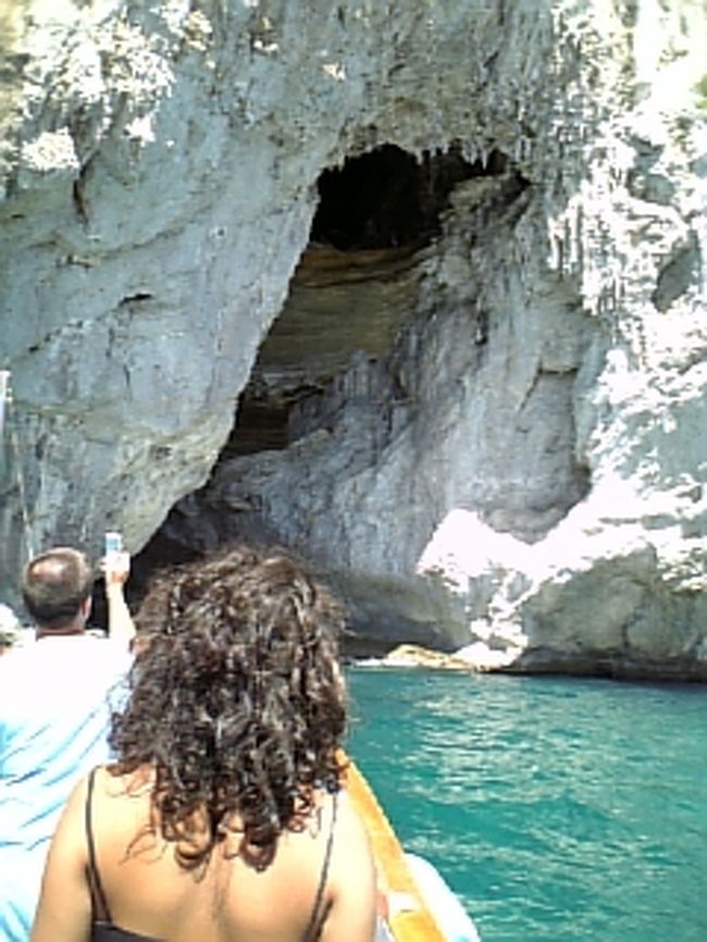 カプリ島一周クルーズ<br /><br />せっかくここまで来たのに、波が高くて、青の洞窟には入れず。<br />島一周のクルーズに出かけました。<br />海の色はホントにエメラルドブルー。<br />こんな色見たことない。<br />島には青の洞窟以外にもいろいろな色の洞窟が・・・<br />中で人が歩いているのが見えました。