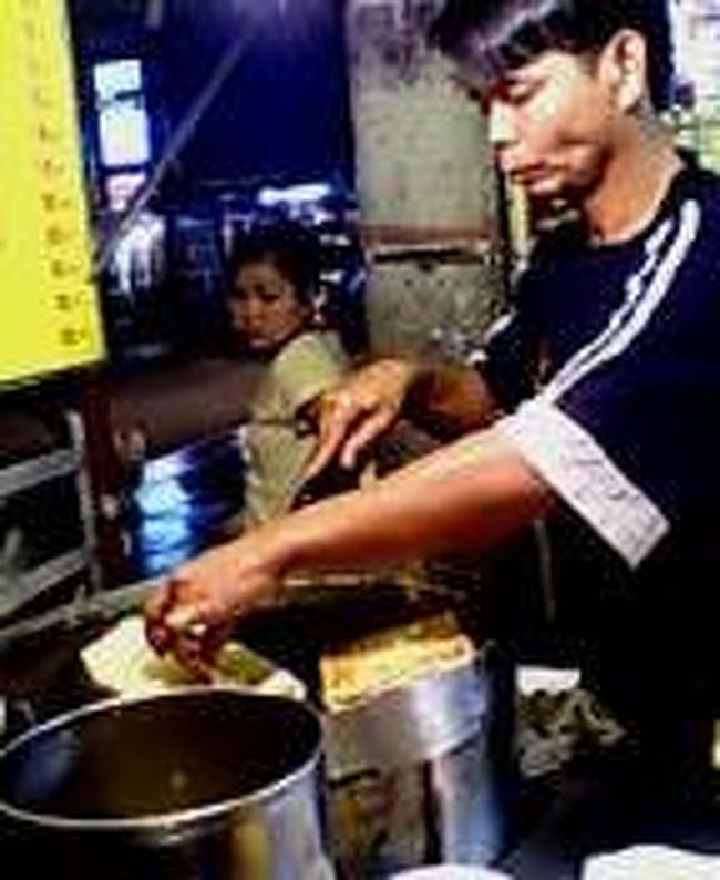 夜。昼間あまりにブラブラしていて、いつのまにか夜のナイトバザーに繰り出していた。<br /><br />チェンマイはこれが有名らしい。<br /><br />とりあえず、ズラーと店が並ぶ。友達に言われていた「ローティ」なるものを作る屋台を発見したので、バナナローティを注文。<br />写真はローティを作るオヤジ。<br /><br />クレープを焼くプレートにパンのような生地を薄くのばして、バターのようなマーガリンのような油を用いて焼く。その上にスライスしたバナナをのせ、くるんでさらに焼き目をつける。焼き上がったローティを一口大に切り、発砲スチロールの入れ物にいれて、上から練乳をかける。砂糖も聞かれるが、これは余程の甘党でない限り、断らなければならない。<br /><br />口に入れた瞬間、あま〜くて香ばしい焼けた生地のパリパリした食感とともに、噛み締めれば噛み締めるほど、熱々になったバナナがその甘味と芳香で、練乳とあわさって、脳天突き刺すウマさだ。<br />シンプルながら、屋台はウマい。