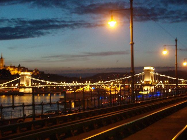 ９月初旬のブダペスト、日没１９時３０過ぎ頃。日没直後で、インターコンチＨ近くのトラム２号線駅辺りからのくさり橋です。<br />これからドナウ川ナイトクルージングに参加するために桟橋向かう途中です。<br />ランプが点灯し、青空が暗くなる直前です。<br />