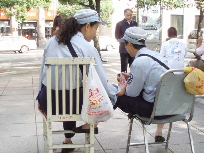週末のせいか、中心地は人の波。人波を避けながら、人民広場・上海博物館へ。<br />途中、駐車違反取締りをしている、おばちゃん２人組みをベンチから観察。ひたすらおしゃべりをしていて、見ていて面白い。<br />このシーンは、三色ボールペンについて、なにやら議論をしている様子。なにを議論するのか。。。