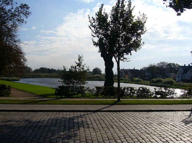 　ハザースレウからバスに揺られる事１時間余り、いよいよリーベの町に到着です。リーベといえば、デンマークの中では少しは名の知れた観光地です。多くの旅行者が、デンマークで最も美しい町、と絶賛しています。ただ、私は正直なところ、事前に写真をみた限りではあまりピンとくるものがなく、実際のところはどうなのか自分の目で確かめたい、という気持ちから、このリーベを目的地の一つとして選びました。<br />　バスは鉄道駅の前に到着し、そこから駅前の通りを町の中心部に向かって歩いていきます。途中、リーベ川に架かる橋を渡ります。穏やかな川の流れと、周囲の芝生や木々の緑が、心に安らぎを与えてくれます。ただ、風が次第に強くなってきました。デンマークは風が強い、と聞いていたのですが、今までは特にそんな感じはしませんでした。ここに来て本領発揮といった感じでしょうか。