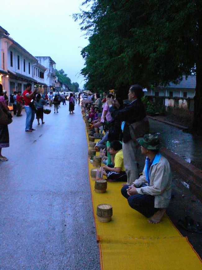 翌日は５時４０分起き。ラオスに来たからには、托鉢を見ないと一日が始まらない。<br /><br />朝６時過ぎのメインストリート。<br />地面に座って僧たちを待つ信者、観光客もちらほら。