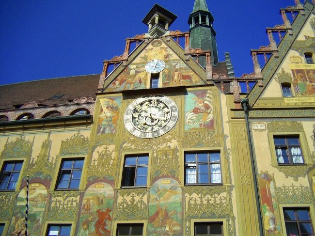 市庁舎の時計。ベージュ色の壁にひときわ目立つている。<br /><br />観光客がたくさん並んで見上げていた。