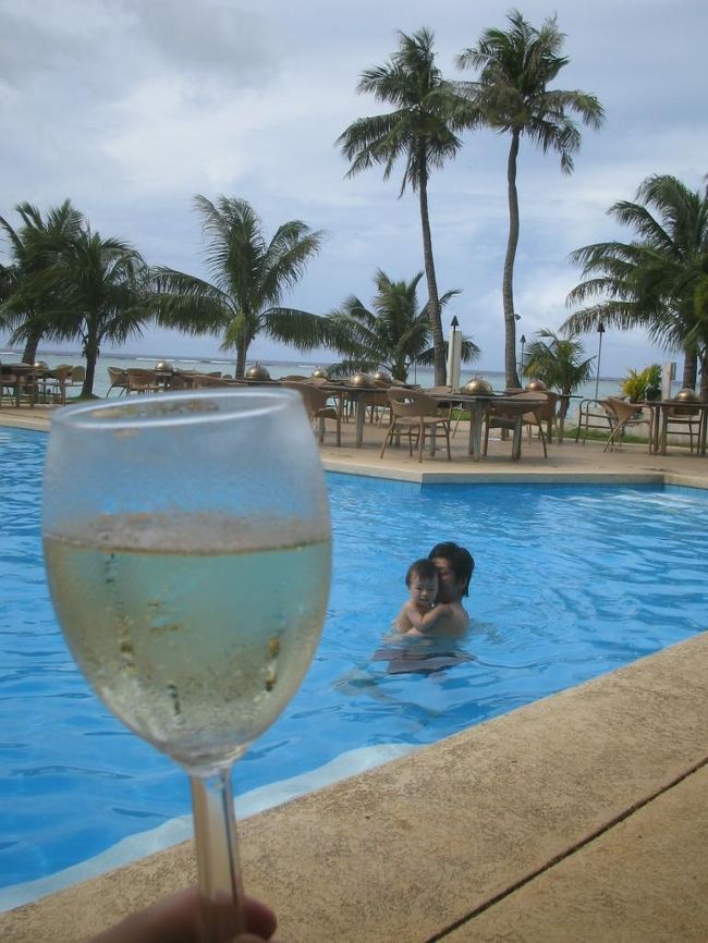 【プール、ふたたび】<br />チャモロビレッジから戻り、いったんホテルで休憩。<br />グアムでは各主要ホテルの目の前に必ずトロリーバスの停車場があるので、いつでも気軽に部屋へ戻って休めます。<br />ベビー連れには非常にありがたい環境ですね。<br /><br />昼寝から覚めたあとは、ふたたびホテルのプールへ。<br />ダンナと息子がパチャパチャ遊んでいる間、私はプールサイドでシャンパンを片手にセレブ気分を満喫。<br />ん〜、リゾート！！<br />ほんの少しの時間だったけど、とっても幸せなひとときだったように思います。<br /><br /><br />写真／シャンパンは5.7ドル。値段も良心的です。