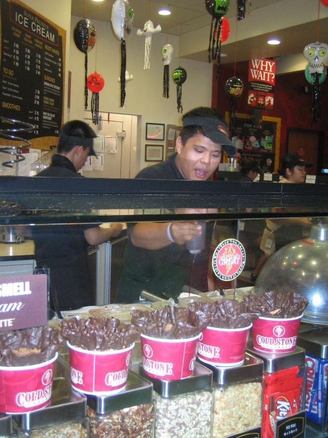 【念願のアイス】<br />プールから上がったあとは、スコールをやり過ごしてから再びおでかけ。<br />昨日ツアーで立ち寄ったマイクロネシアモールへ向かいました。<br />島内最大のショッピングモールです。<br /><br />良かったのは下記のお店です。<br /><br />＊KB TOYS<br />いかにもアメリカンなおもちゃ屋さん。手押し車などの大型遊具や知育玩具が日本で買うよりずっと安くて、欲しいものだらけだったけど、荷物が大変なことになるので泣く泣く諦めました。<br /><br />＊macy's<br />デパートのメイシーズがテナントとして入っています。小さいけれど、ラルフローレンのキッズ&amp;ベビーがあって、日本で買うよりハンパなく安いのでオススメです。<br /><br />＊レスポートサック<br />種類豊富、価格もぐっとリーズナブルで目移りしまくり。グアム、ハワイ限定柄のバッグもアリ。<br /><br />＊ファンタスティックパーク<br />屋内遊園地とゲームセンターがセットになった場所。ゴーカートやメリーゴーランドもあるので子連れ向き。息子はここでいろんな車に乗車しました。お金入れてないけど。。<br /><br /><br />...で、掲題のアイス。<br />日本では行列必至の「コールドストーンクリーマリー」があったのです。<br />しかも全然並ばなくてOKなので、これは食べておかなくては！<br />この店、ベースのアイスとトッピングを選ぶと、それをスタッフが陽気に歌いながら冷たい石の上でミックスしてくれます。<br />最後にはそのアイスをポンッと空中に投げてカップにイン！<br />お見事な技に拍手、すると息子も喜んで拍手してくれました。<br /><br /><br />写真／コールドストーンクリーマリーの陽気なスタッフ。今回は既にセットになっているオススメアイスを頼んだけど、やっぱりちょっと甘めなので、次回があったら自分でベースとトッピングを選びたいと思いました。