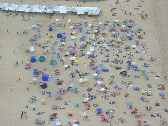 オ・シティオからナザレの海岸のパラソルの花を眺めています。