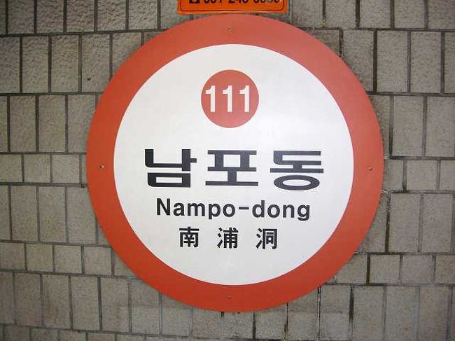 14:55　地下鉄で釜山駅へ<br /><br /><br />時間はすでに15時前。そう、もうすでに約束の時間。 <br />私たちは携帯を持っていないため、こちらから連絡を取るしか無く・・・ <br />韓国も日本同様、公衆電話が少なくなっているようで、どこでも簡単には見つけられません。 <br /><br />まぁ、そんな経緯から地下鉄に乗ることにしました。 <br /><br />写真は南浦洞（ナンポドン／Nampo-dong）の駅の看板です。 <br />色と番号で初めての人でもわかりやすく作られています。<br /><br /><br />■Photolibrary<br />http://www.photolibrary.jp/img58/69_177599.html
