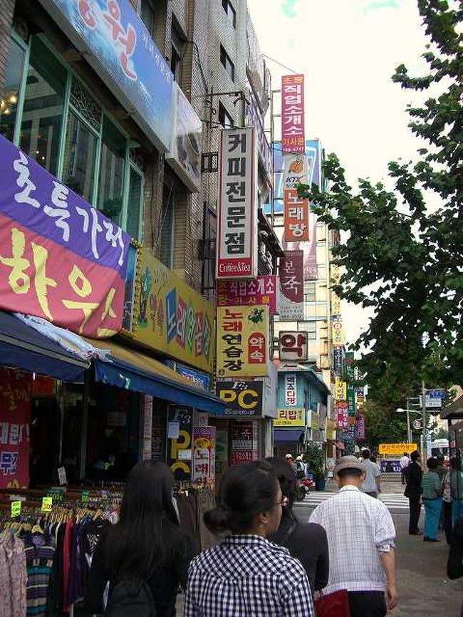 15:50　中央路（チュンアンノ）沿いの光景<br /><br /><br />釜山（プサン／Busan）駅から太宗台（テジョンデ／Taejongdae）に行くためには市内バスに乗らなければなりません。<br />事前にＭさんが調べておいてくれたバスに乗るためにバス停へ移動します。<br />釜山駅の大通り、中央路（チュンアンノ／Jungangno）を渡るとこんな感じの光景が広がっていました。<br />駅前だというのに意外とローカルな感じでした。<br /><br /><br />■Photolibrary<br />http://www.photolibrary.jp/img58/69_177997.html