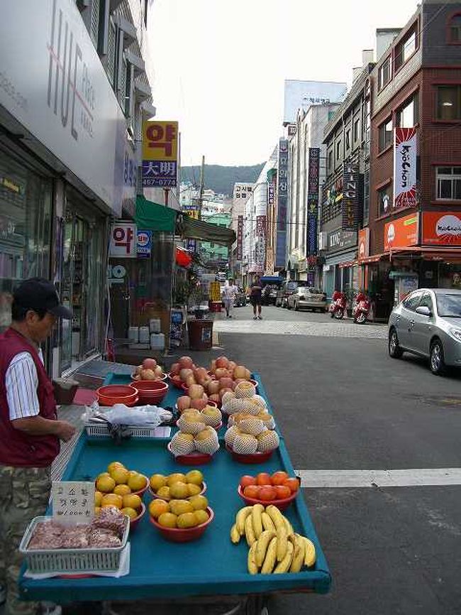 草梁洞（チョリャンドン）の光景<br /><br /><br />てっきりバス停はターミナルかと思っていたら、釜山（プサン／Busan）駅前の中央路から出ているようでした。つまり、始発じゃなかったわけですね。 <br /><br /><br />釜山駅から見ると中央路（チュンアンノ／Jungangno）から先のエリアが草梁洞（チョリャンドン／Choryang-dong）というエリアになります。<br /><br />一本入るだけで雰囲気ががらりと変わります。道ばたで商品を並べている姿もあり、大都会のイメージも変わります。<br /><br /><br />■Photolibrary<br />http://www.photolibrary.jp/img60/69_178216.html