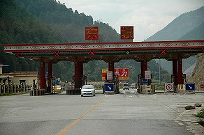 香格里拉の町を出て２時間１５分ほど。<br />１１時１５分頃、東坡料金所を通過。<br />ここで運転手さんは７元の支払い。<br /><br />ここまで下りてくると、虎跳峡観光の拠点≪虎跳峡鎮≫の小さい町も目の前。