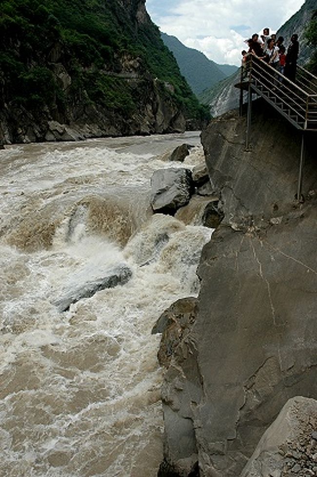 それまで虎跳峡を緩やかに流れて来た金沙江が激しい流れに変わる虎跳石のあたりを振り返る。<br /><br />迪慶チベット族自治州側の遊歩道で歓声を挙げる人たちの声もかき消される水音。