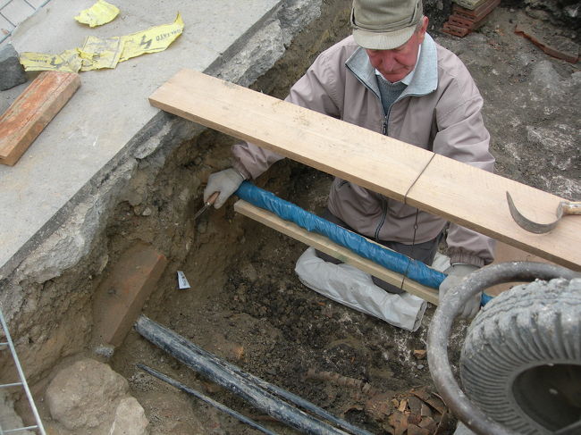 教会の前の広場で人骨の発掘作業をしていました。一輪車の車輪の下に頭蓋骨や脊柱が見えます。