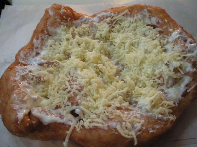 市場で地元の人が行列して買っていたおやつ。<br />しかも、外国人観光客がガイドブックでこれを探している人を見かけました。それでチャレンジ。<br />すると、外国人観光客が買ったものと同じのを注文すると後ろに並んでいたおばちゃんがチーズをトッピングしなさいとアドバイスをくれた。実は最初に注文したのはプレーン。どうやら地元は違いチーズとたぶんサワークリームをトッピングしたほうが美味しいし人気。<br />ラッキーまたしても人に助けられました。<br />最初の印象と変わりハンガリーの人が好きになりました。<br />このおかしの名前は不明。薄く伸ばしたあげパンにチーズとサワークリーム。ほどよい甘さとチーズの塩分とサワークリームの酸味がバランス良く小腹がすいたときにぴったりのおやつ。美味しかった。