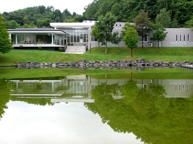 美術館の入り口からクラフト工房の方を見た風景。池に建物が映えている。